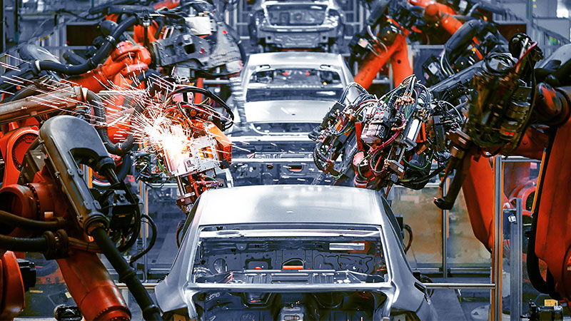 Cars on assembly line in factory.