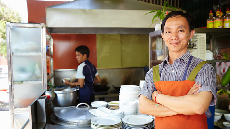 Man standing in front of take out counter.