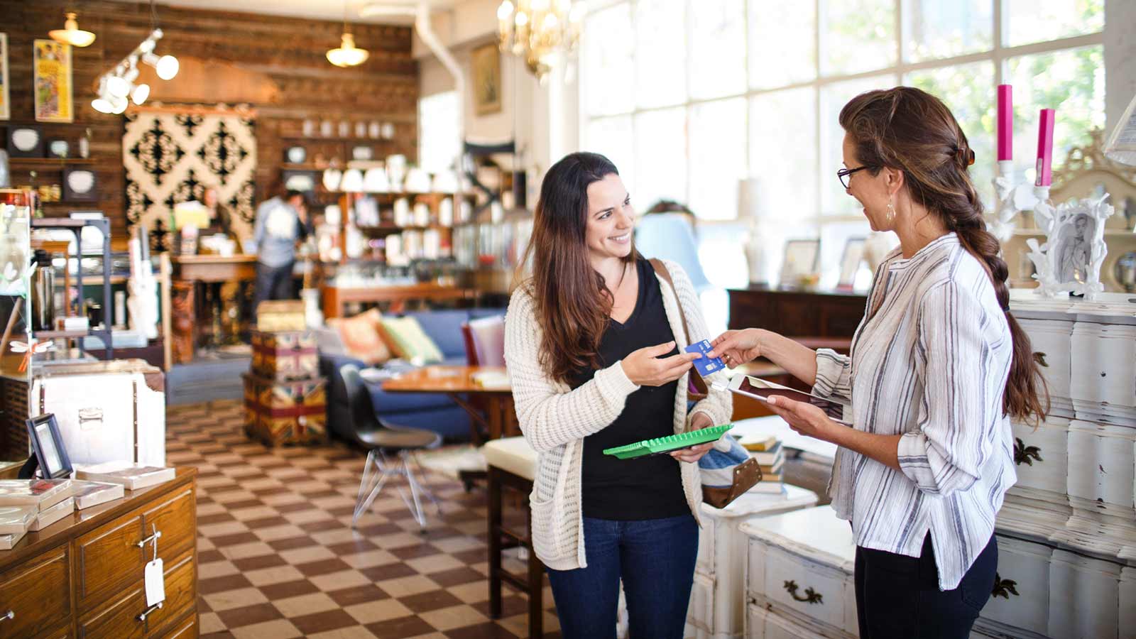 Merchant handing a Visa card back to a customer.